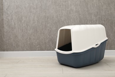 One cat litter box on floor indoors, space for text copy