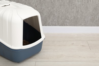 One cat litter box on floor indoors, space for text copy