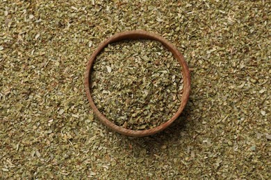 Photo of Dried oregano and wooden bowl, top view