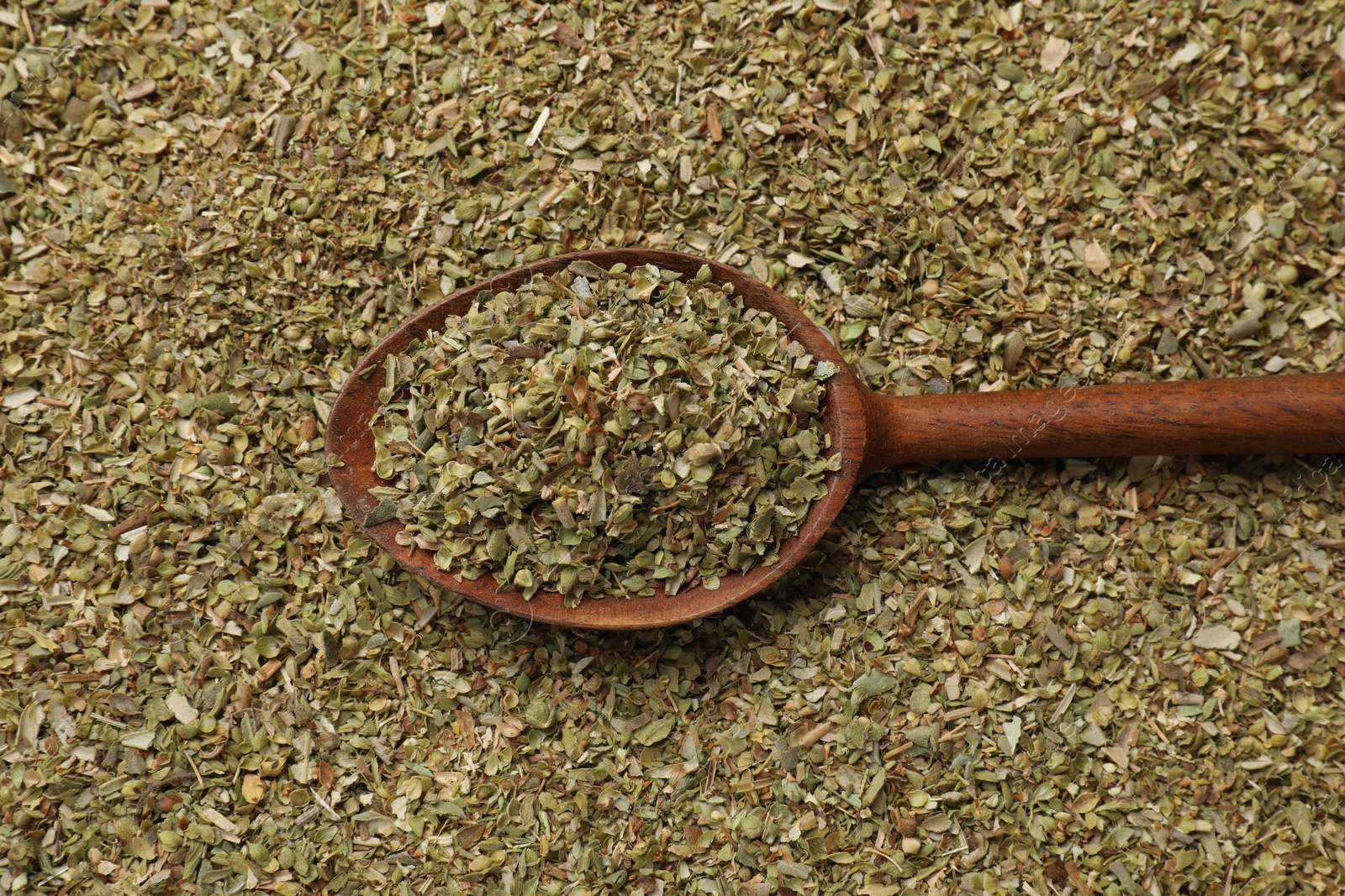 Photo of Dried oregano and wooden spoon, top view