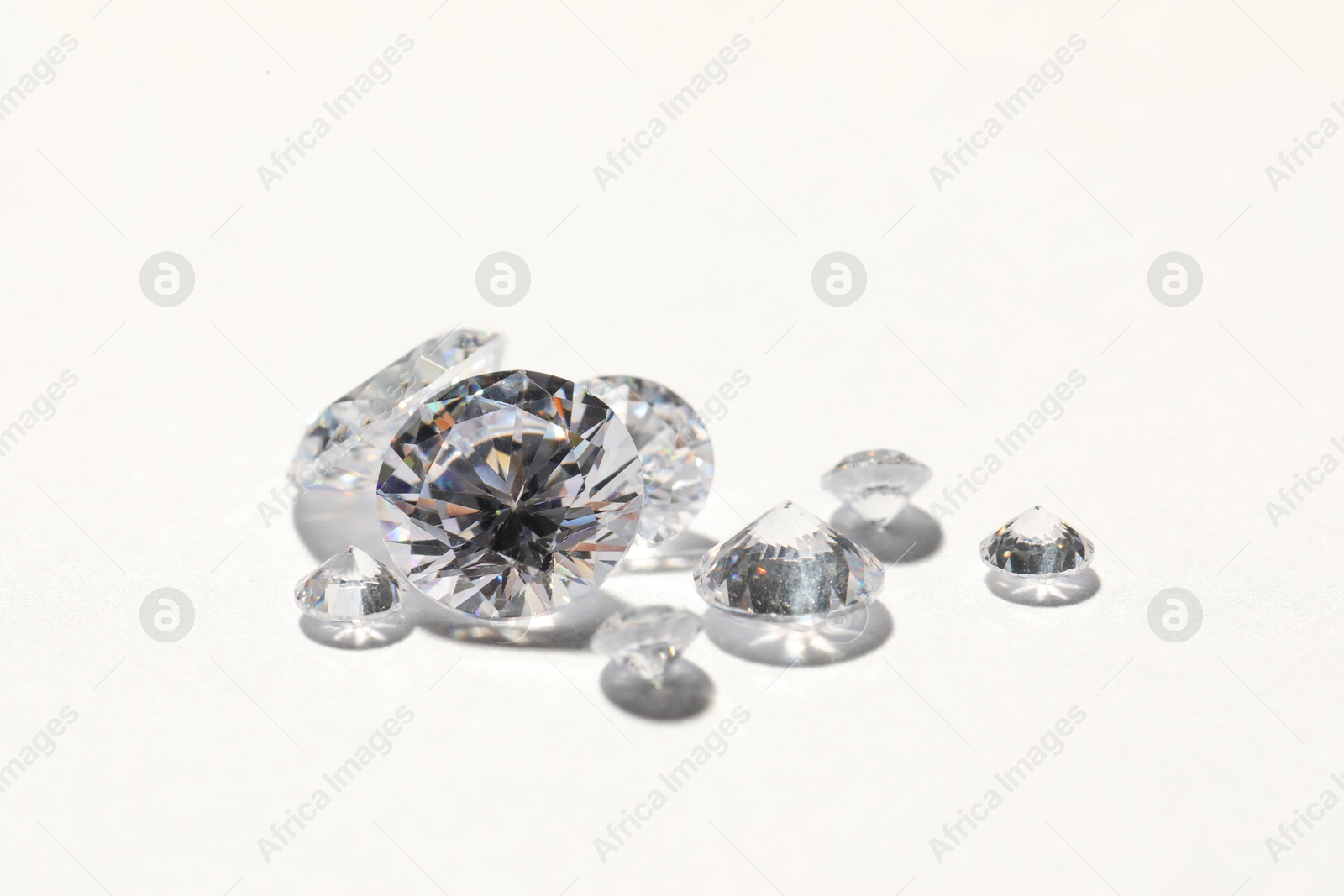 Photo of Many beautiful shiny diamonds on white background, closeup