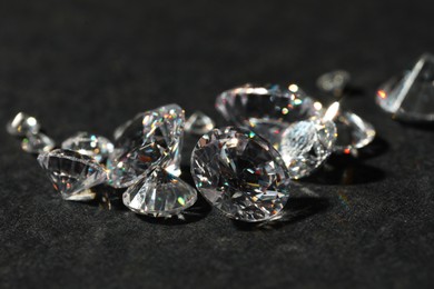 Photo of Many beautiful shiny diamonds on black table, closeup