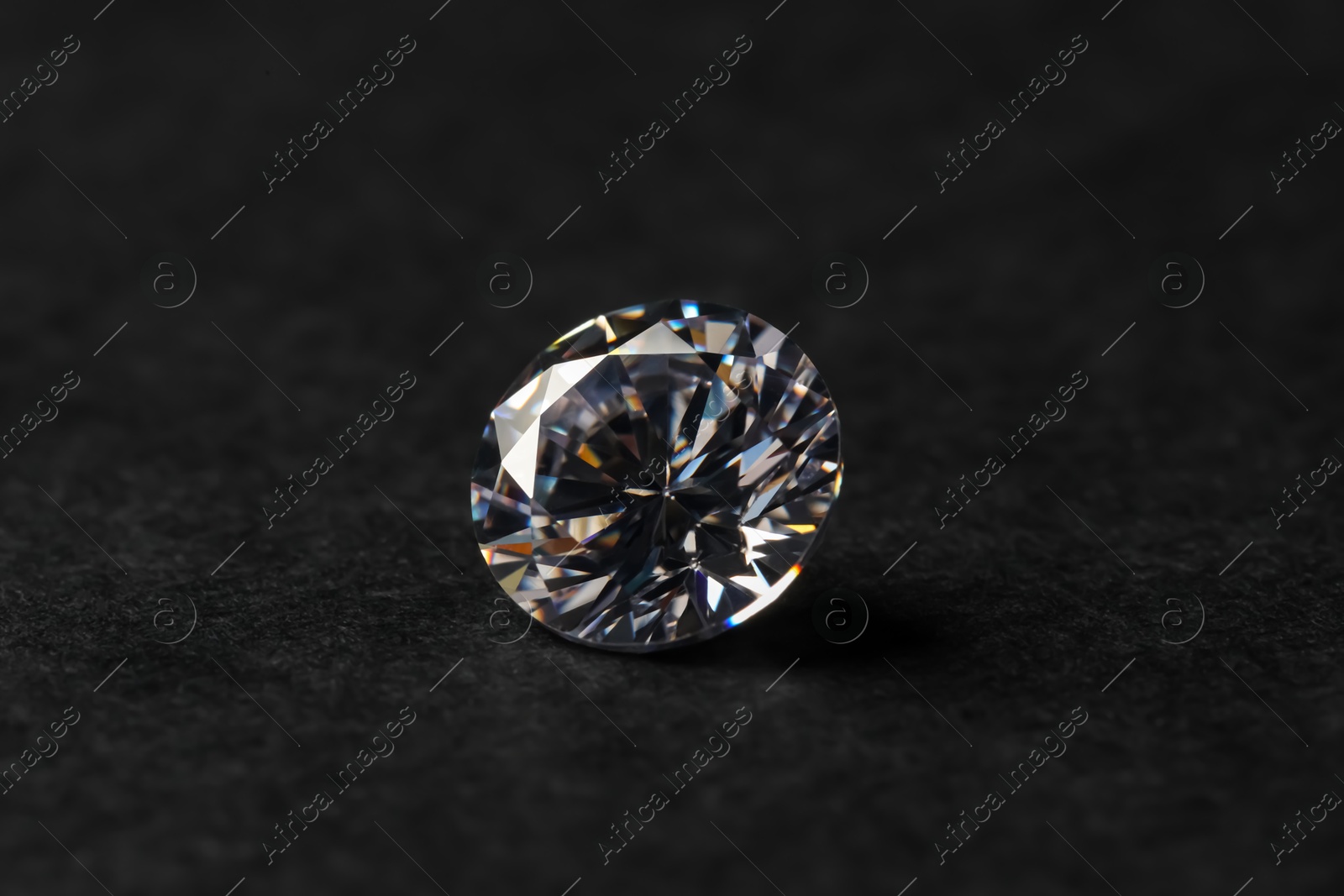 Photo of Beautiful shiny diamond on black table, closeup