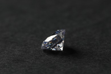 Beautiful shiny diamond on black table, closeup