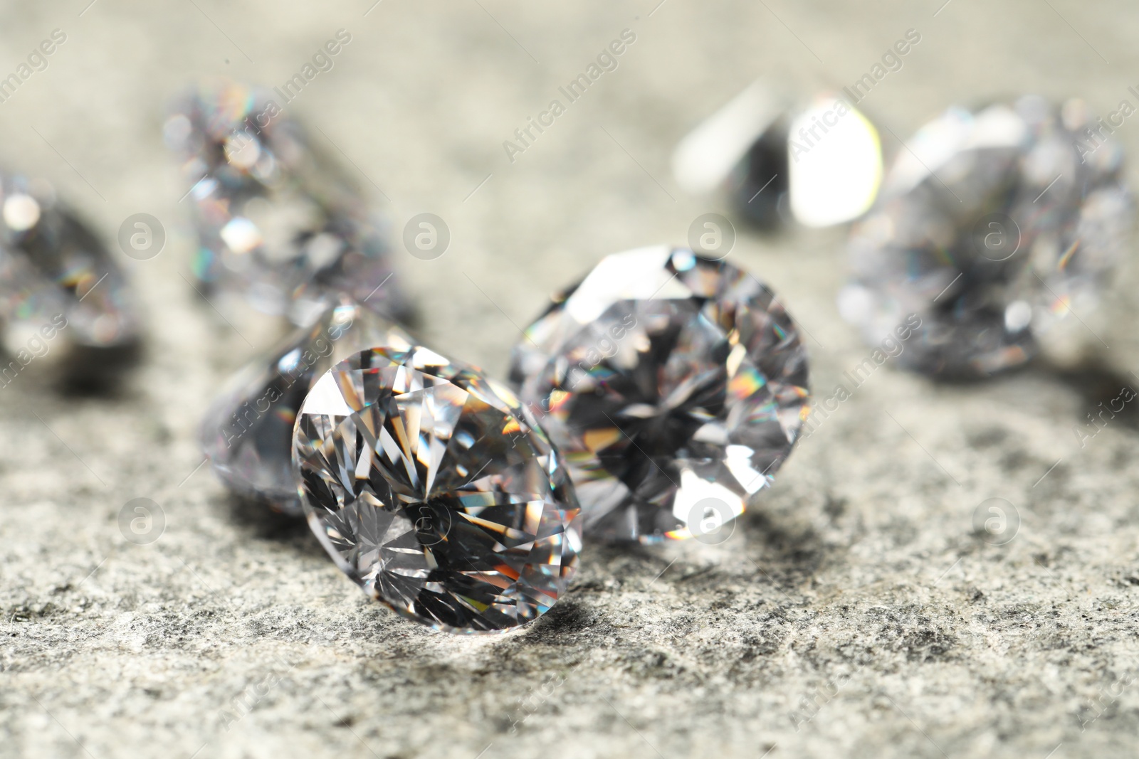 Photo of Many beautiful shiny diamonds on grey table, closeup