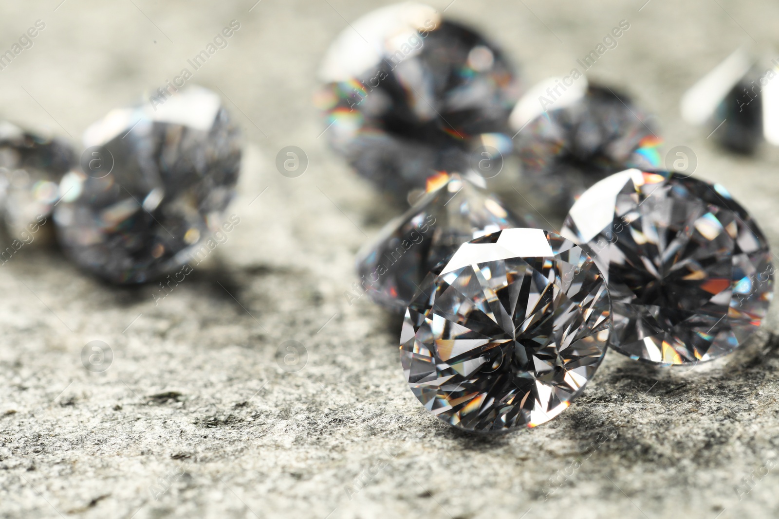 Photo of Many beautiful shiny diamonds on grey table, closeup