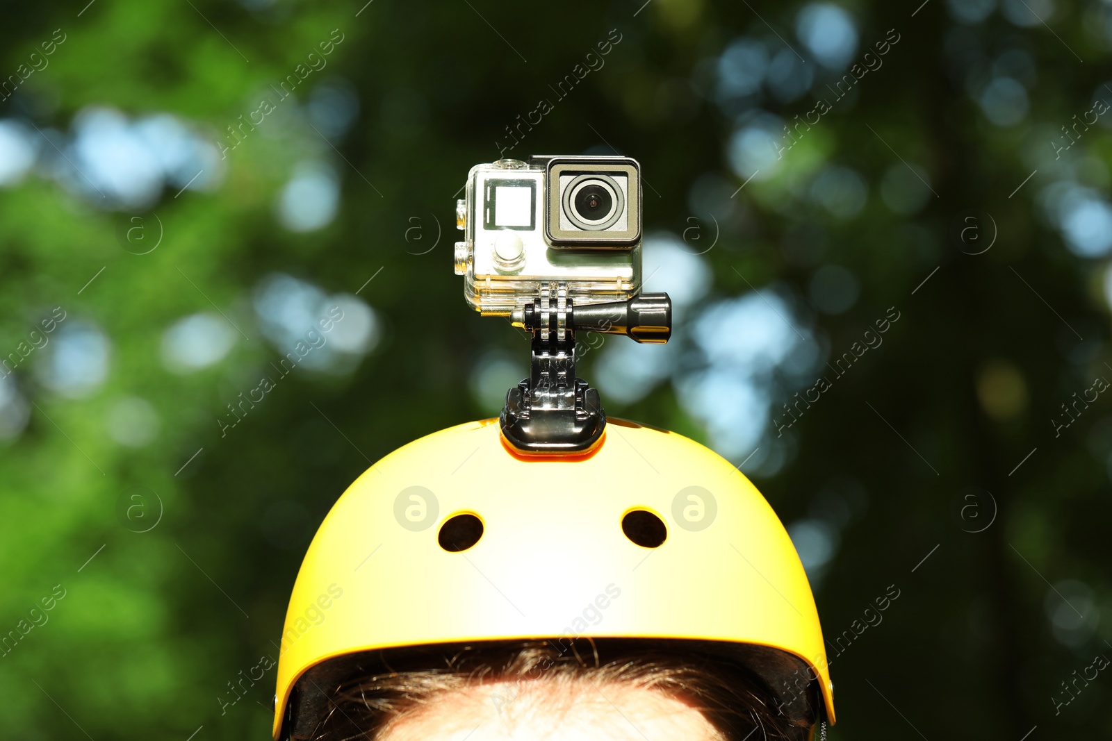 Photo of Man with modern action camera on helmet outdoors, closeup