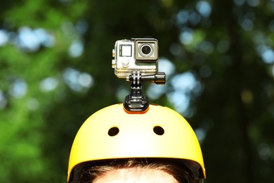 Photo of Man with modern action camera on helmet outdoors, closeup