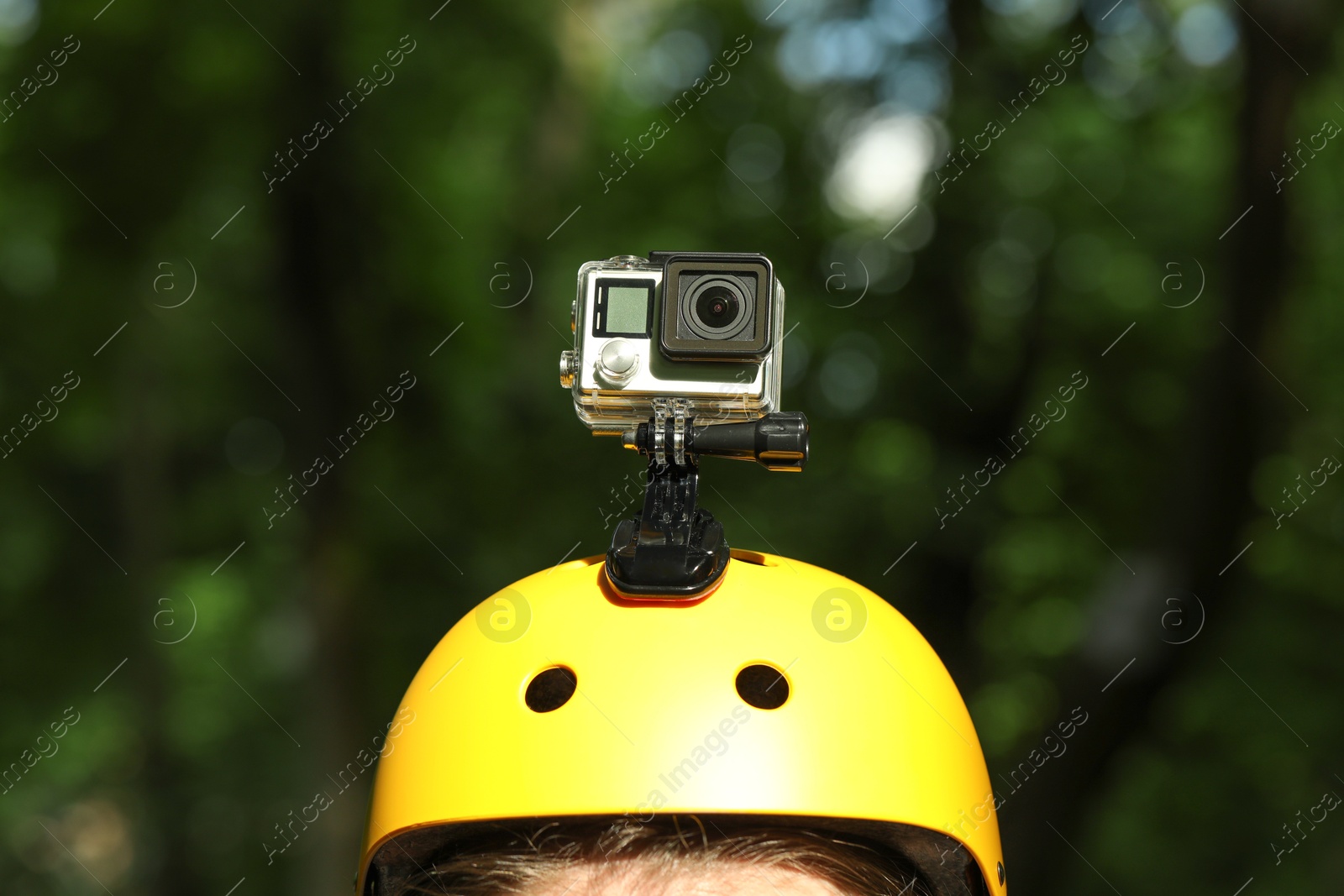 Photo of Man with modern action camera on helmet outdoors, closeup