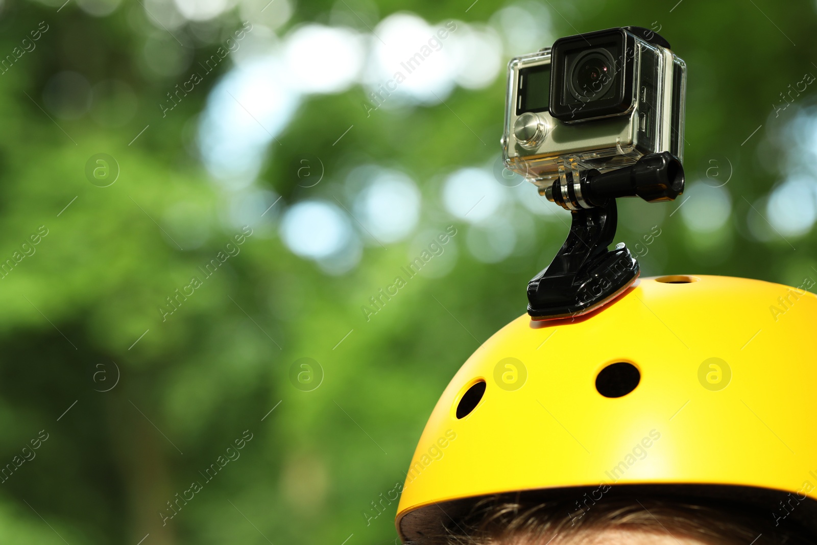 Photo of Man with modern action camera on helmet outdoors, closeup. Space for text