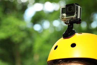 Photo of Man with modern action camera on helmet outdoors, closeup. Space for text