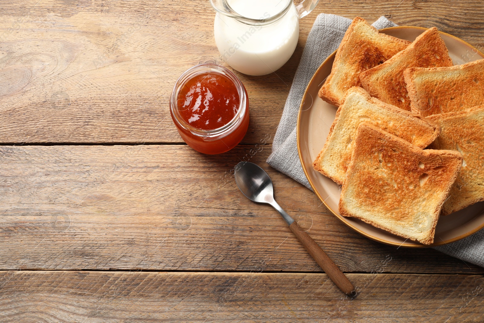 Photo of Delicious toasts served on wooden table, flat lay. Space for text