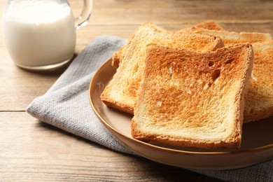 Photo of Delicious toasts served on wooden table, closeup