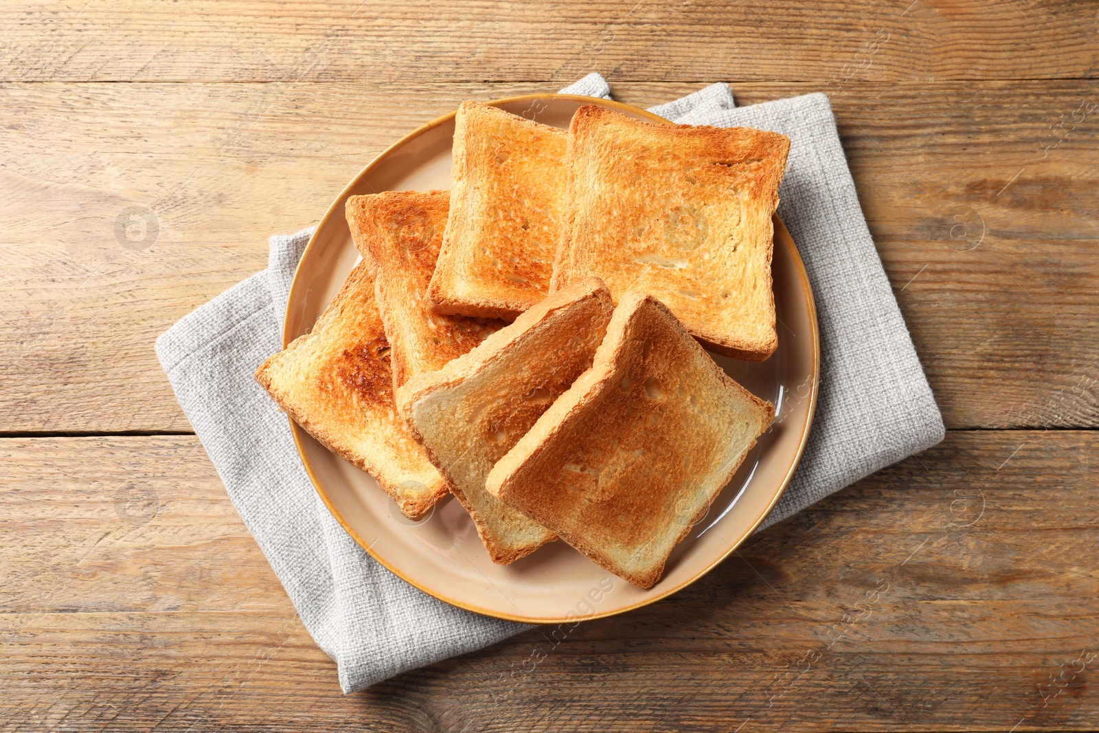 Photo of Delicious toasts on wooden table, top view