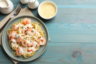 Photo of Delicious pasta with shrimps served on blue wooden table, flat lay. Space for text