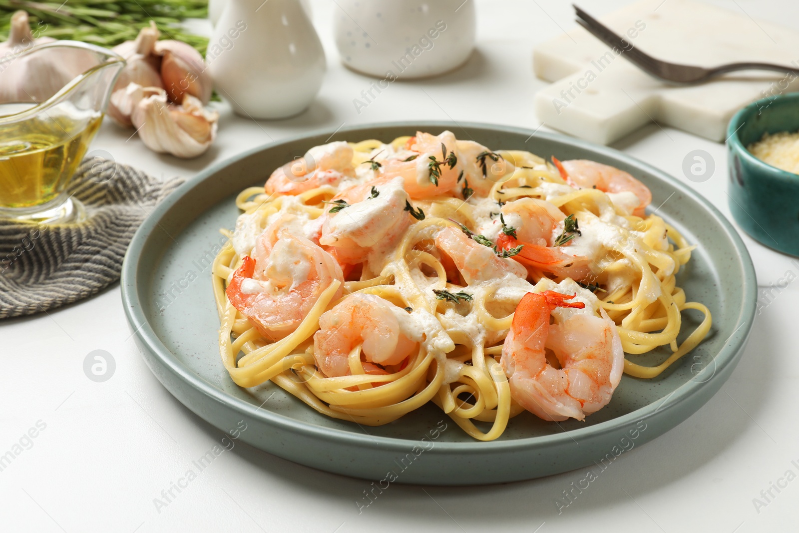 Photo of Delicious pasta with shrimps served on white table, closeup