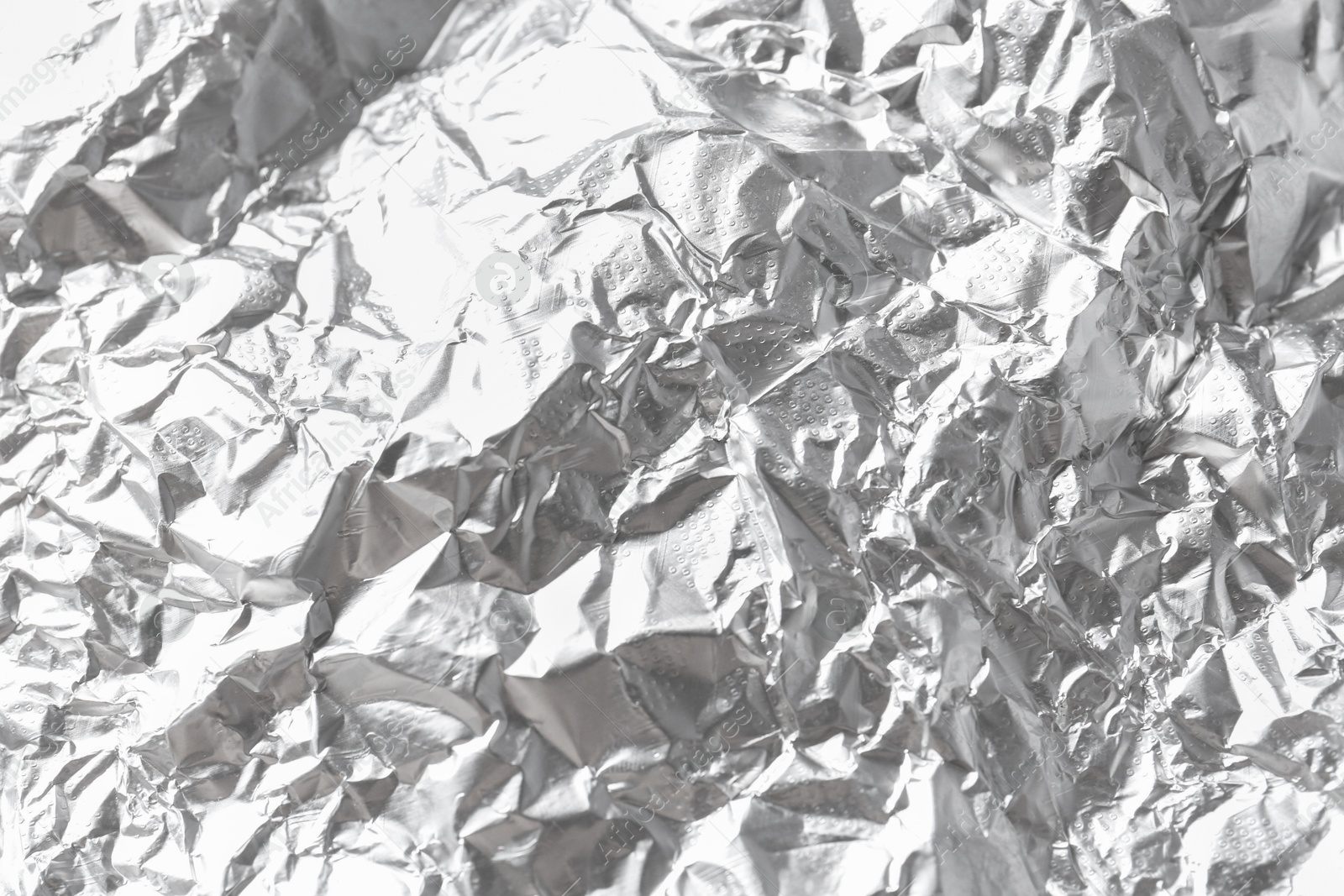 Photo of Shiny silver tinfoil surface as background, closeup