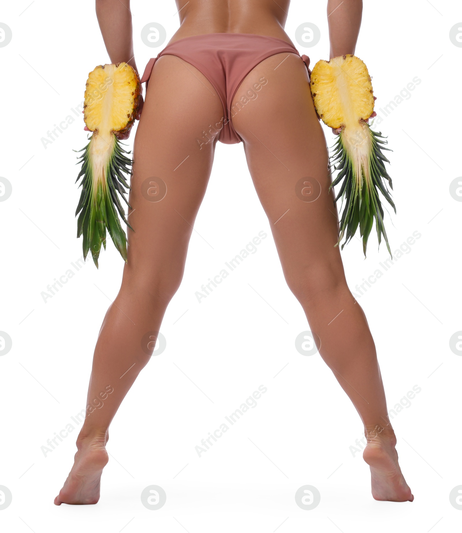 Photo of Woman in bikini with halves of pineapple on white background, closeup