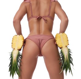 Photo of Woman in bikini with halves of pineapple on white background, closeup