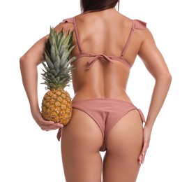 Woman in bikini with fresh pineapple on white background, closeup