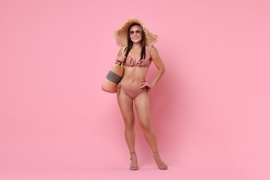 Woman in stylish bikini on pink background