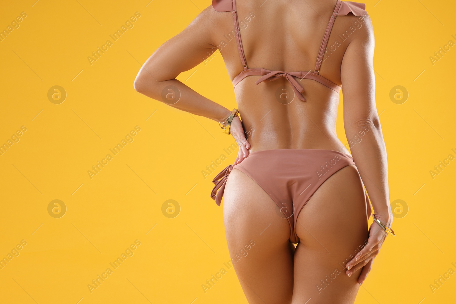 Photo of Woman in stylish bikini on orange background, closeup. Space for text