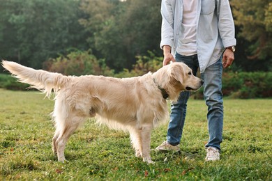 Photo of Man with cute Golden Retriever dog on spring day, closeup