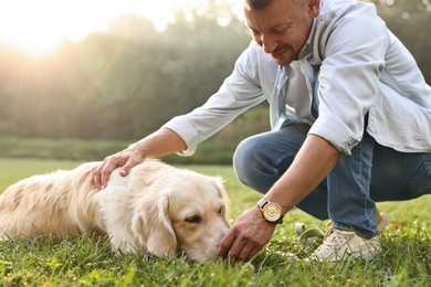 Photo of Man with cute Golden Retriever dog on spring day