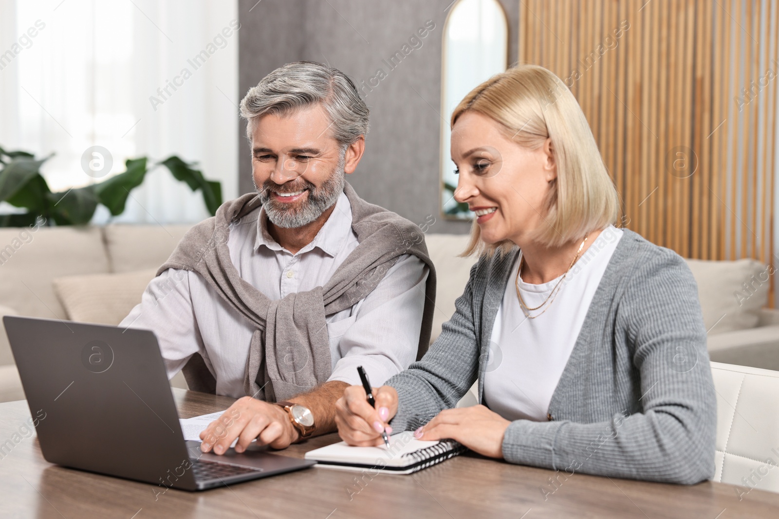 Photo of Couple planning pension budget at table indoors