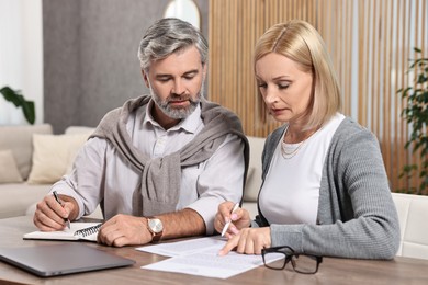 Couple planning pension budget at table indoors