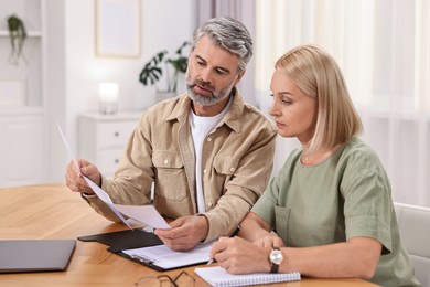 Couple planning pension budget at table indoors