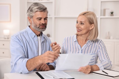 Pension savings. Couple planning budget at table indoors