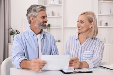 Pension savings. Couple planning budget at table indoors