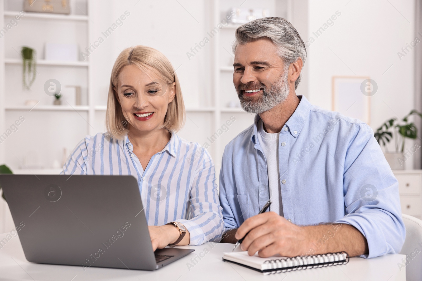 Photo of Pension savings. Couple planning budget at table indoors