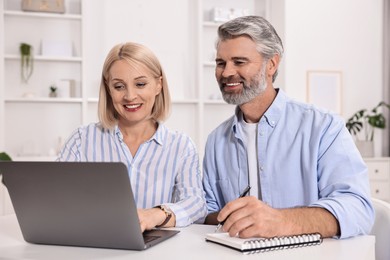 Pension savings. Couple planning budget at table indoors