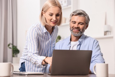 Pension savings. Couple planning budget at table indoors