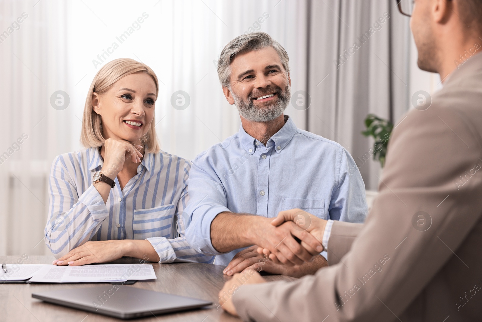 Photo of Pension plan. Couple consulting with insurance agent at table indoors