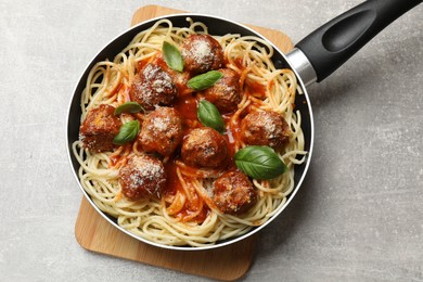 Delicious pasta with meatballs on light grey table, top view