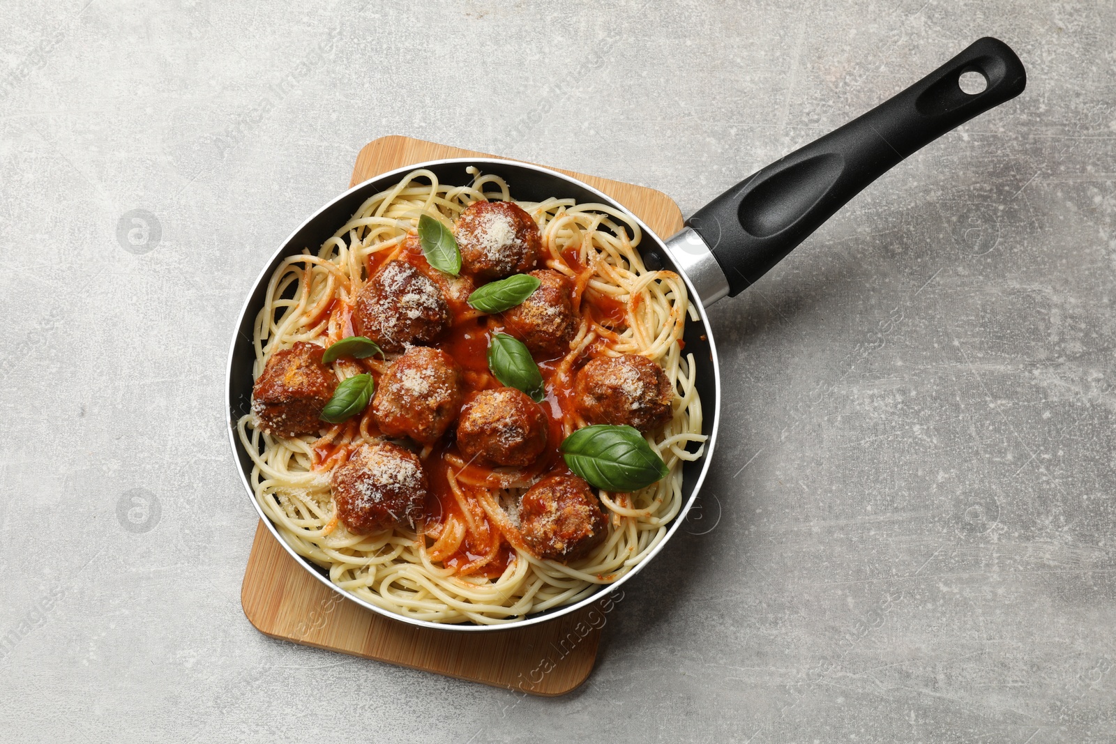 Photo of Delicious pasta with meatballs on light grey table, top view