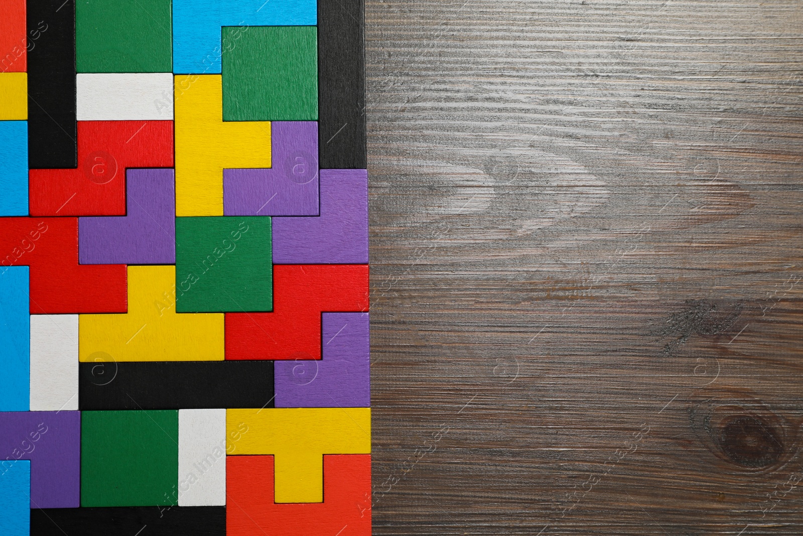 Photo of Colorful puzzle pieces on wooden table, top view. Space for text