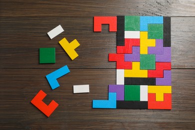 Photo of Colorful puzzle pieces on wooden table, top view