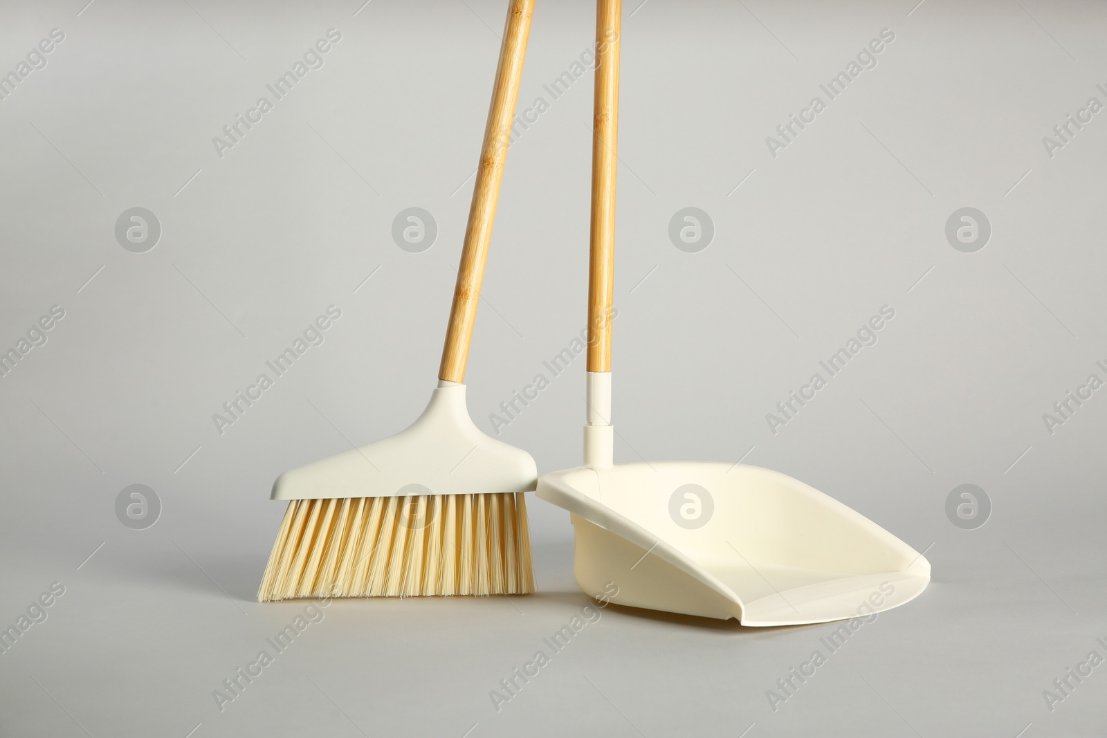 Photo of Cleaning broom and dustpan on grey background