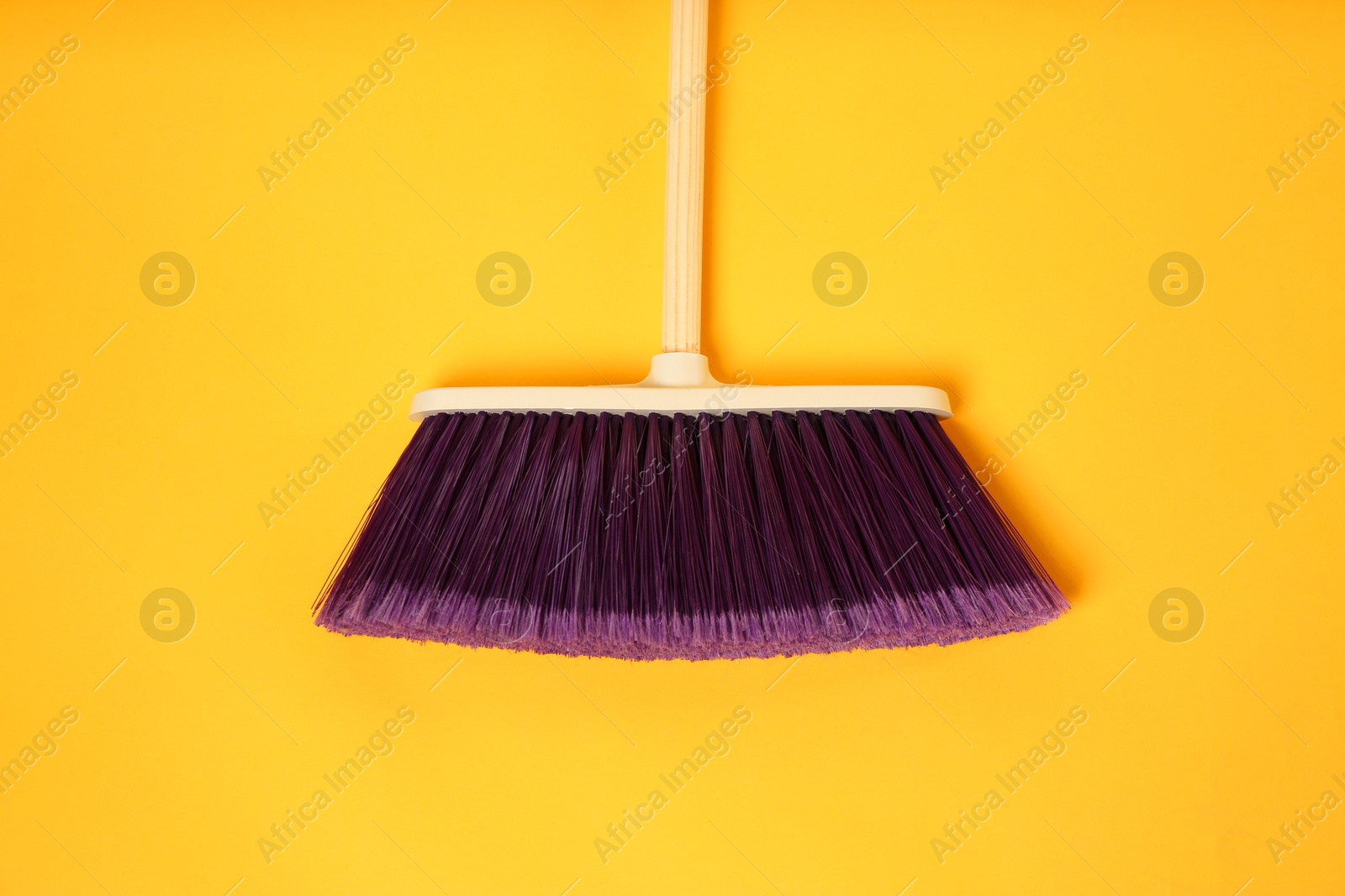 Photo of One cleaning broom on orange background, top view