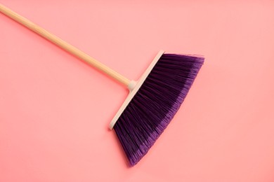 Photo of One cleaning broom on pink background, top view