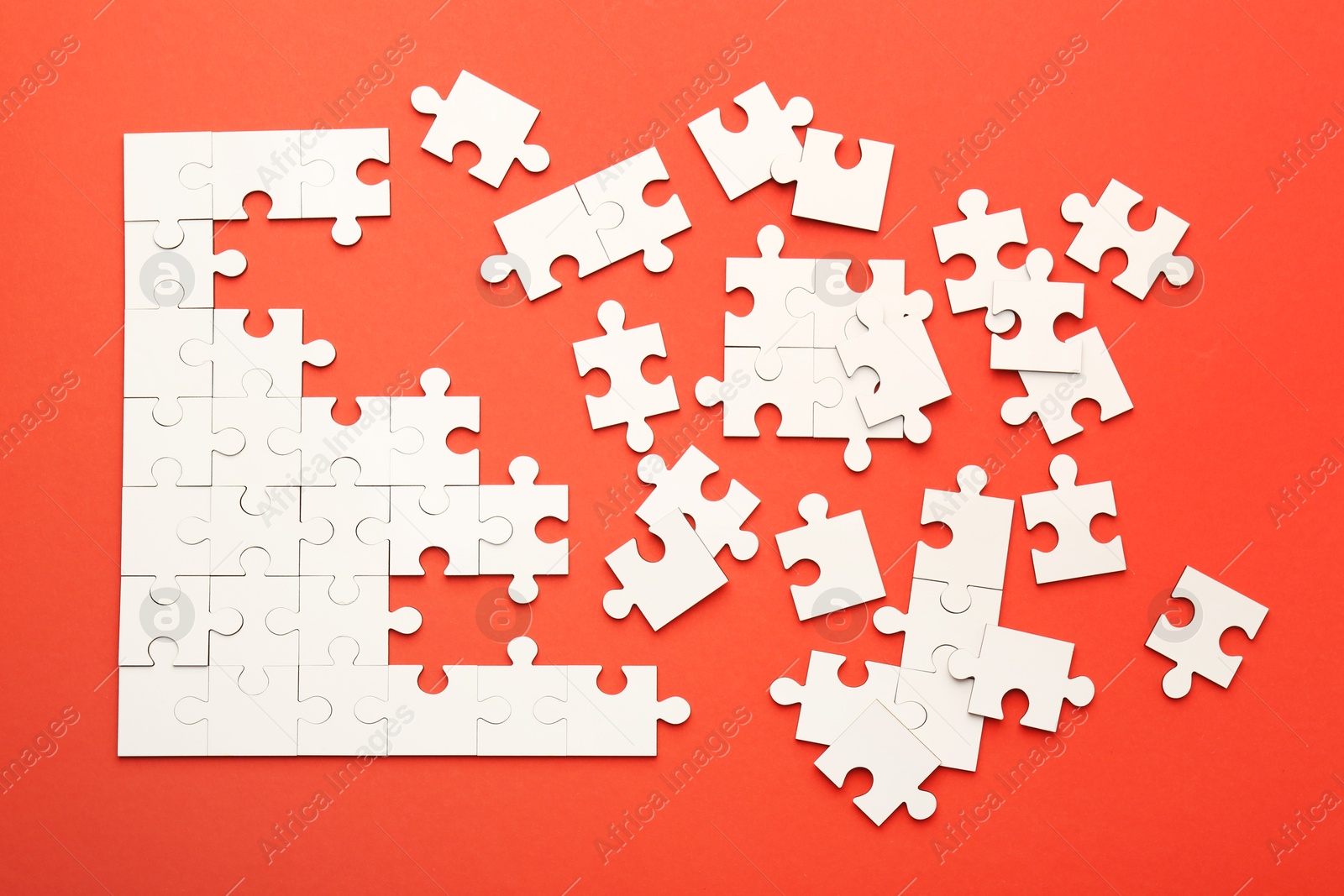 Photo of White puzzle pieces on red background, top view