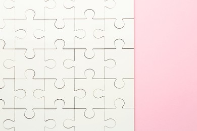 Photo of White puzzle on pink background, top view