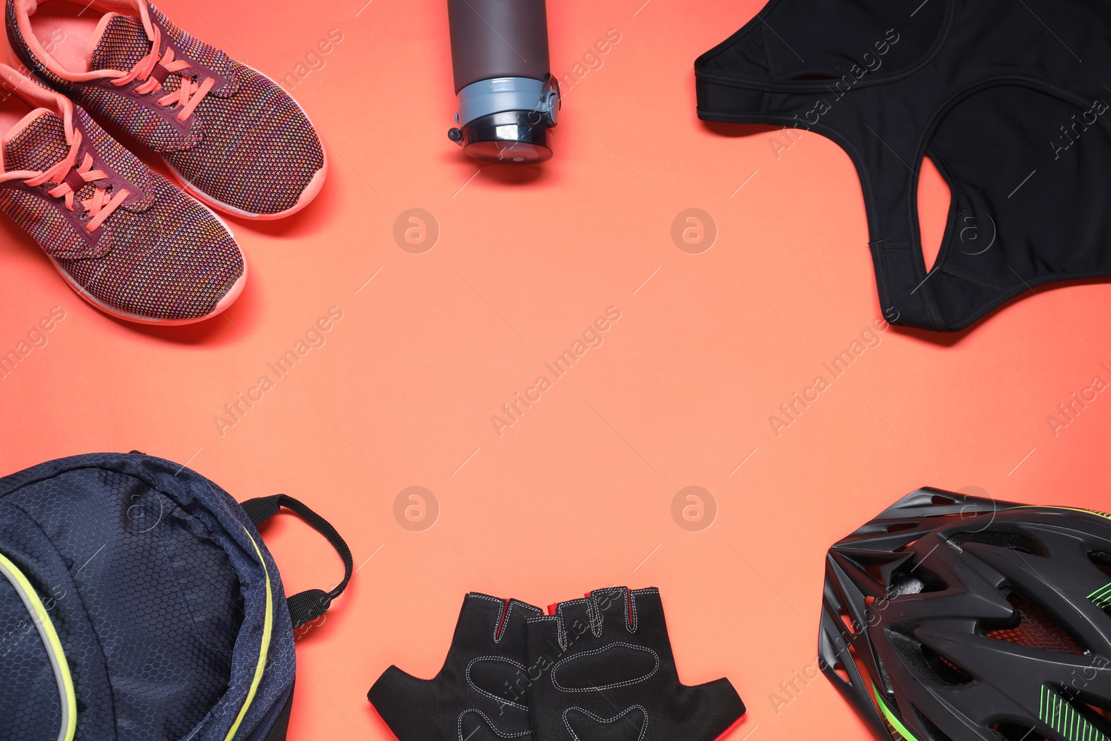 Photo of Flat lay composition with cycling accessories on coral background. Space for text