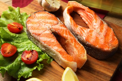 Photo of Tasty grilled salmon steaks and vegetables on table, closeup