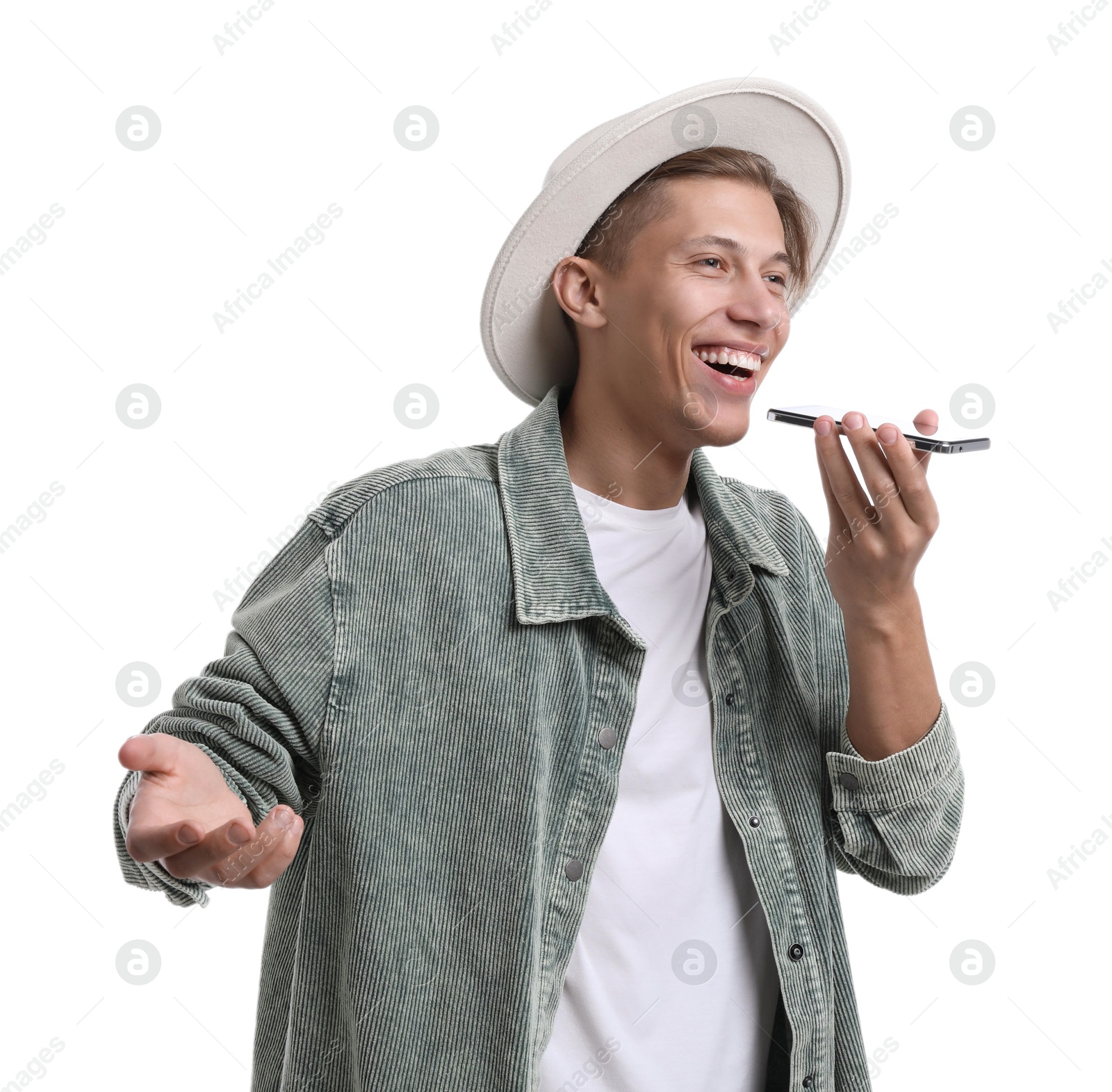 Photo of Young man in hat recording voice message via smartphone on white background