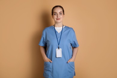 Photo of Professional nurse with badge on dark beige background